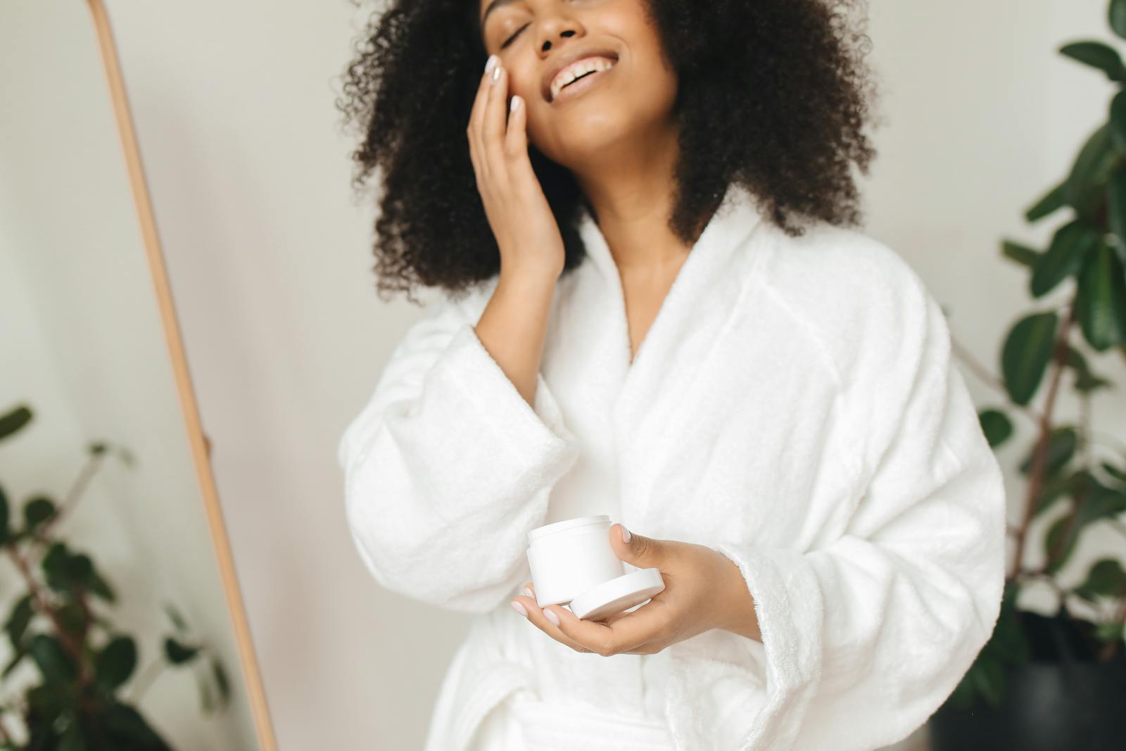 Woman with glowing skin applying skincare